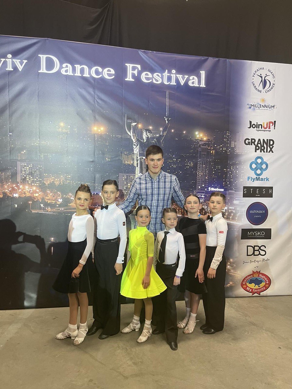 MBM coach and young dancers in competition costumes at the Lviv Dance Festival